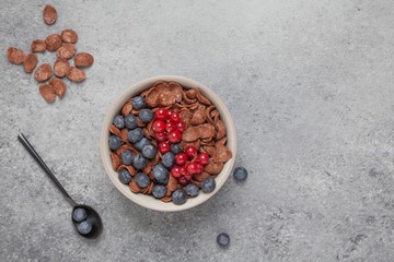 Chocolate corn flakes in a bowl with milk and berries. Delicious healthy Breakfast.