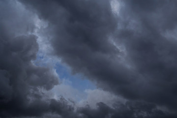 Naklejka na ściany i meble Dramatic storm dark grey cumulus clouds against blue sky background texture