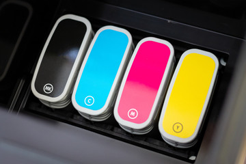 Inkjet printer CMYK ink cartridges inside printers slot.