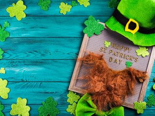 St Patrick Day greetings on letter board on dark green wooden rustic background with shamrocks and...