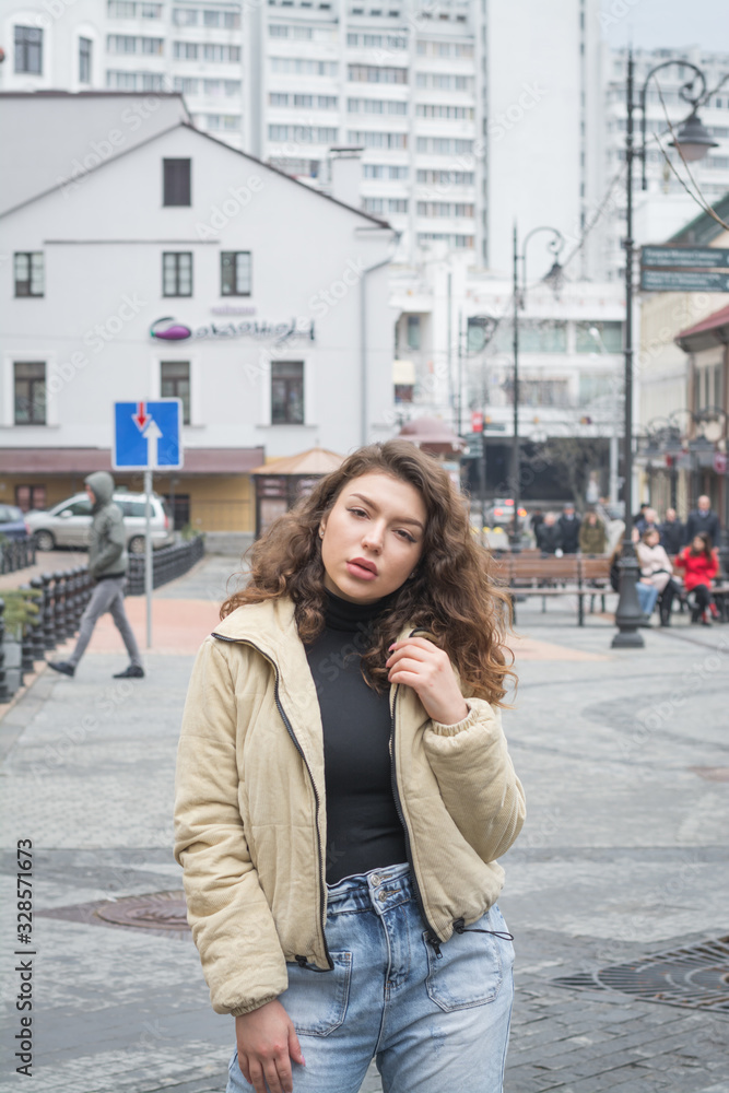 Wall mural Stylish modern girl posing for a photo in the street