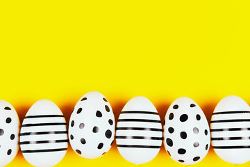 Easter composition. Beautiful painted eggs on bright yellow background. Flat lay, top view. Copy space for your text.