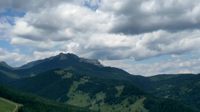 Time lapse video of green forest, aerial view of summer forest and moving clouds in Romanian Carpathians.