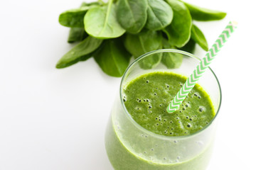 Freshly made green smoothie made of vegetables, fruits, herbs and greens. Glass of blended vegan beverage with ingredients around. Top view, close up, copy space, background.