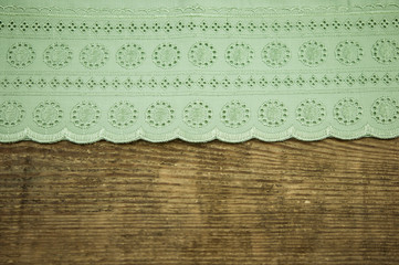  green tablecloth with lace on old vintage wooden table