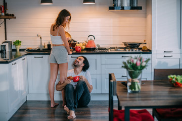 Young loving couple in the morning in the kitchen at home