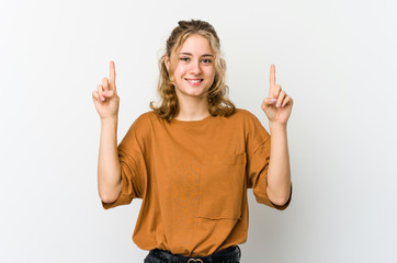 Young caucasian woman on white backrgound indicates with both fore fingers up showing a blank space.