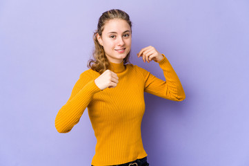 Young caucasian woman on purple background celebrating a special day, jumps and raise arms with energy.