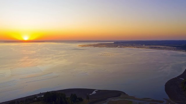 Aerial time lapse with the ocean at sunset. salmon and mussel farms in the sea