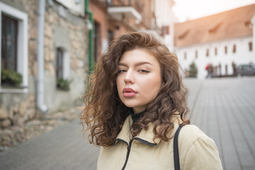 Portrait of a beautiful girl on the streets of the city in cloudy weather