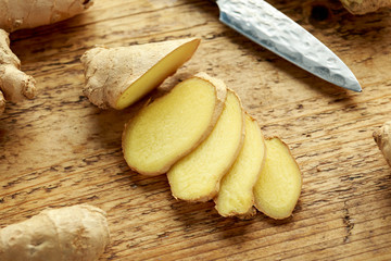 Fresh slice of Ginger on wooden chopping board. healthy food