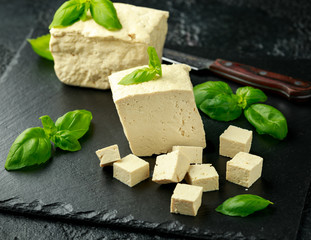Organic Soy Tofu with basil on dark rustic stone board