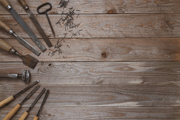 Vintage woodworking tools on a wooden background. Chisels, file, puncher and nails  neatly...