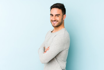 Young caucasian man isolated on blue background happy, smiling and cheerful.