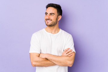 Fototapeta premium Young caucasian man isolated on purple background smiling confident with crossed arms.
