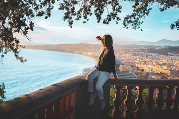young female watching sunset in Nice, France. beautiful panoramic aerial cityscape top view of French riviera. Landscape of harbor, town of Cote d'Azur France. longhair woman enjoying evening near sea