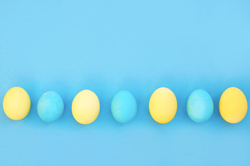Easter blue and yellow eggs on blue background. Greeting Easter Spring Card