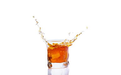 Whiskey with splash on white background, brandy in a glass