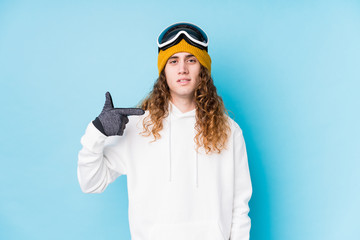 Young caucasian man wearing a ski clothes isolated  person pointing by hand to a shirt copy space, proud and confident