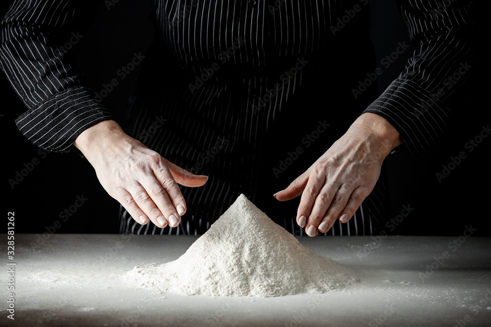 Wall mural Flour on a kitchen table on a black moody background in the morning light