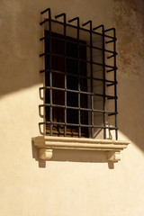Obraz premium Caratteristica finestra con sbarre in centro storico di antica città . Portogruaro, Veneto, Italia. Fotografia notturna.
