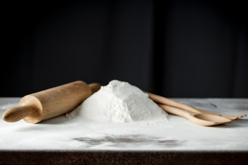 Flour on a kitchen table on a black moody background in the morning light