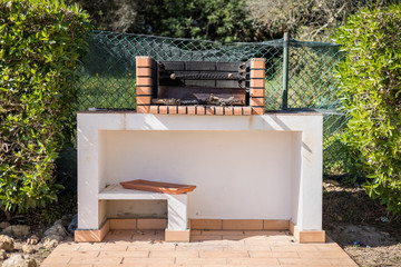 Charcoal barbecue in red brick in a garden