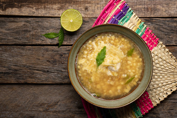 Mexican corn grain boiled also called esquites with cheese and mayonnaise on wooden background