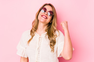 Young caucian woman with glasses isolated on pink background celebrating a victory, passion and enthusiasm, happy expression.