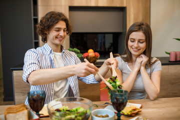 Romantic evening, couple eating healthy food at home kitchen with wine glasses