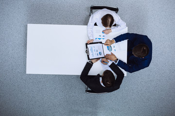 Group of business people analyzing financial documents, view from above. Business team at meeting