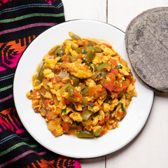 Mexican scrambled eggs with tomato and chili pepper also called "a la mexicana" on white background