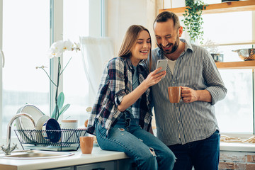 Smiling man and woman looking at the smartphone screen stock photo