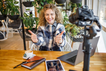 Portrait of gorgeous woman blogger in casual wear posing to the camera and smiling