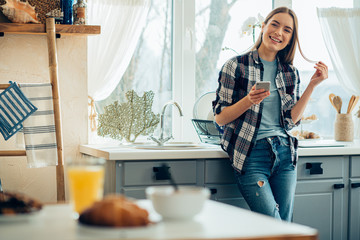Relaxed young lady with smartphone at home stock photo