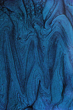 Vertical abstract banner with liquid nail polish texture.Navy blue.Negative space for text or design.Beautiful stains of liquid nail polish,fluid art technique.Marble background.