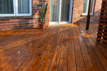 Backyard wooden deck floor boards with fresh brown stain - 328586251