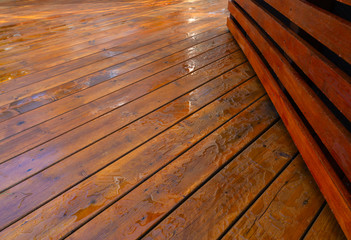 Backyard wooden deck floor boards with fresh brown stain - 328586405