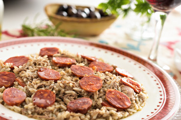 Table set for a dinner. A typical portuguese dish is being served, made with rice, duck meat and chorizo sausage.
