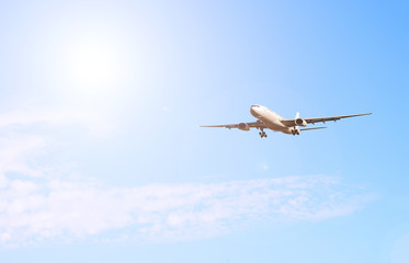Airliner on the background of the sky with the sun white