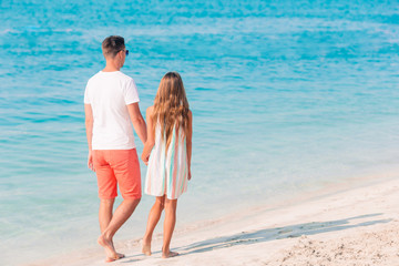 Little girl and happy dad having fun during beach vacation