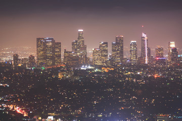 Beautiful super wide-angle night aerial view of Los Angeles, California, USA, with downtown district, mountains and scenery beyond the city, seen from the observation deck of Griffith Park observatory