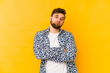 Young caucasian man isolated on yellow background who is bored, fatigued and need a relax day.