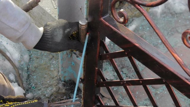 weld the hinged gates,closeup work on welding hinges on forged metal Wicket gate