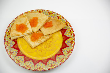 Pancakes with red caviar on a light background with beautiful bokeh