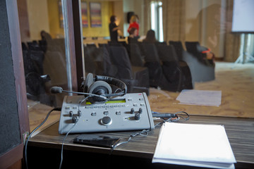 interpreting - Microphone and switchboard in an simultaneous interpreter booth . Soft focus of...