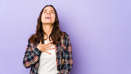 Fototapeta premium Young mixed race hispanic woman isolated laughs out loudly keeping hand on chest.