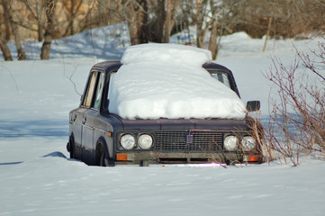 Snow covered car in the open field