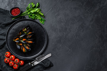 Mussels in tomato sauce decorated with parsley and cherry tomatoes. Black background. Top view. Space for text