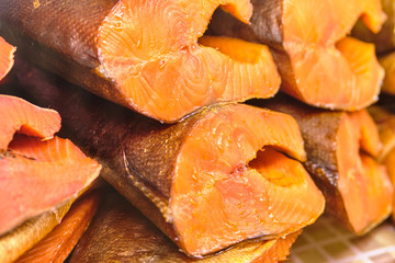 Smoked red fish in a section on a store counter.